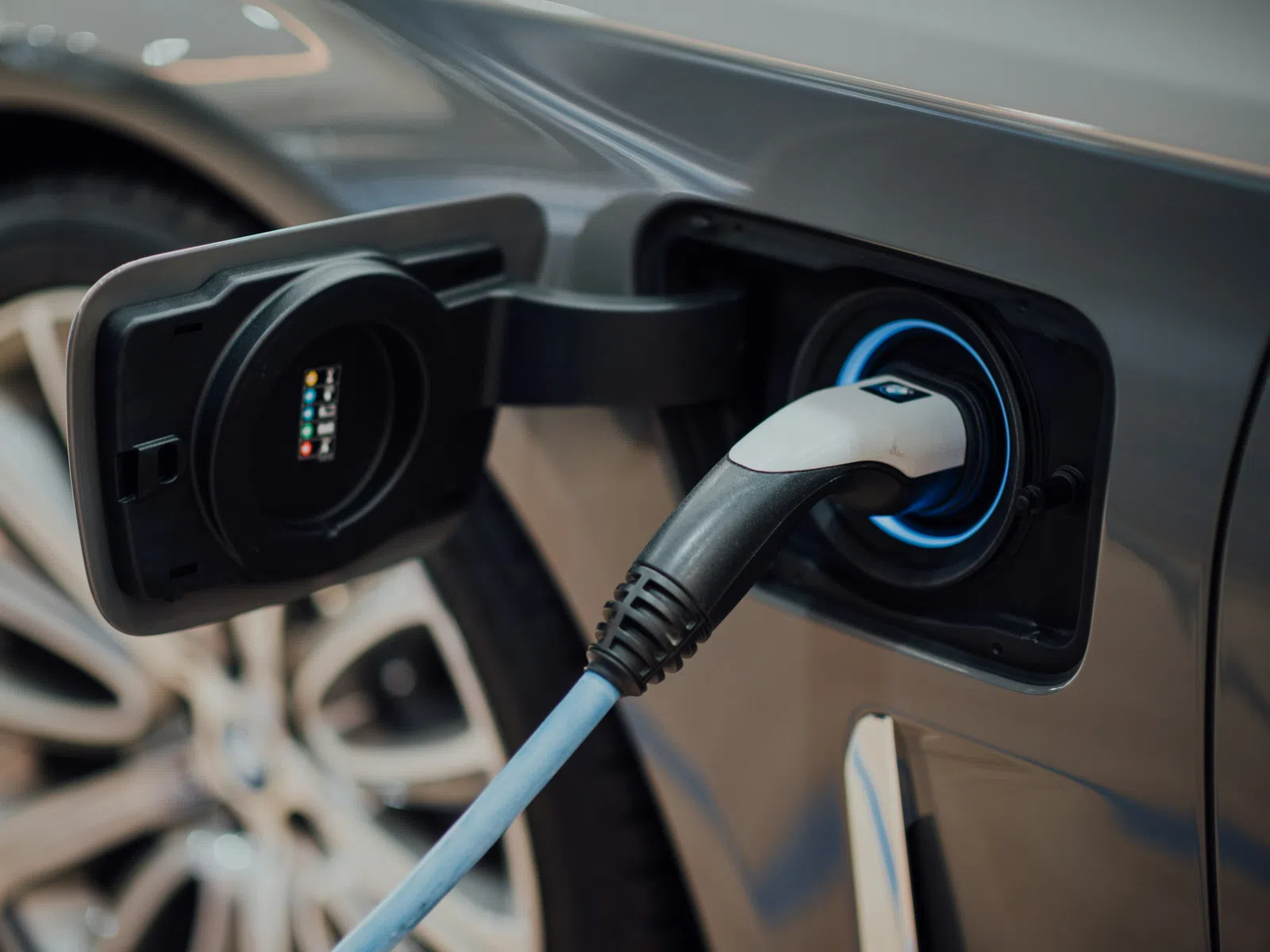 Close-up of an electric vehicle charging port with a charging cable plugged in, highlighting clean energy technology.