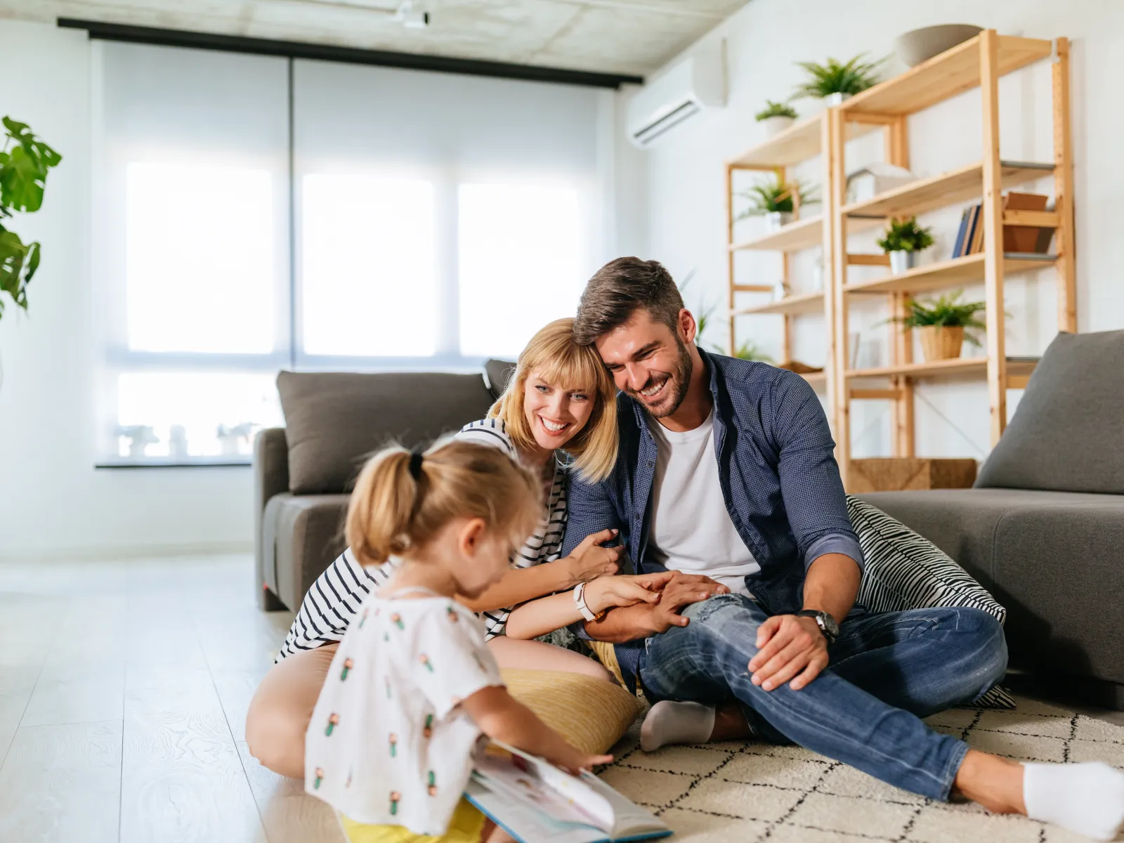 Smiling couple sitting on sofa reviewing documents and using calculator together in cozy living room