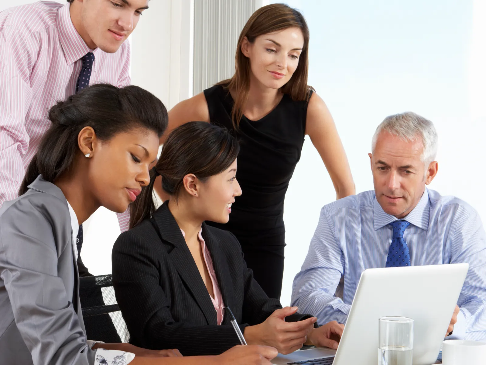 a group of people looking at a laptop