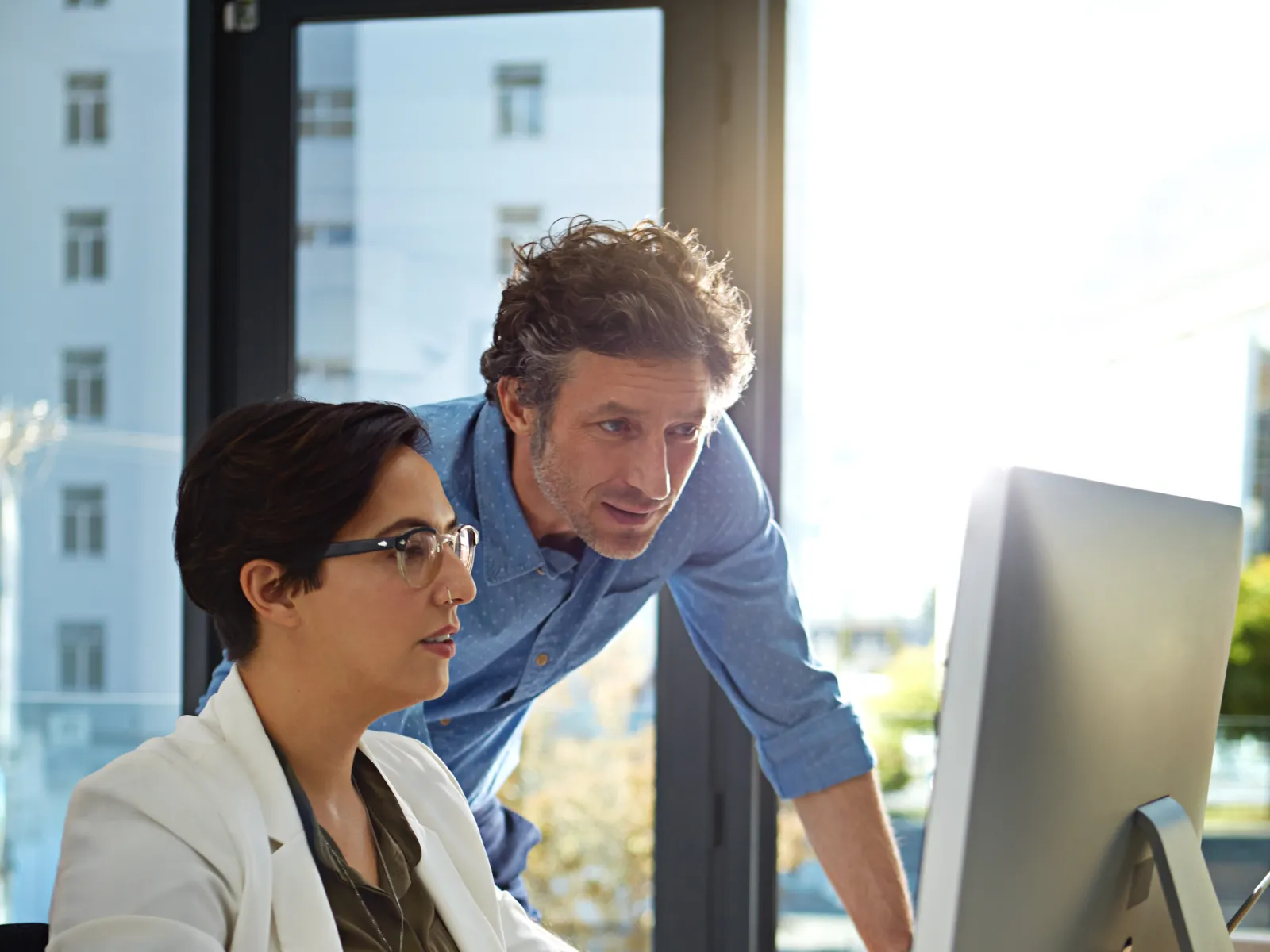 a man and a woman looking at a computer