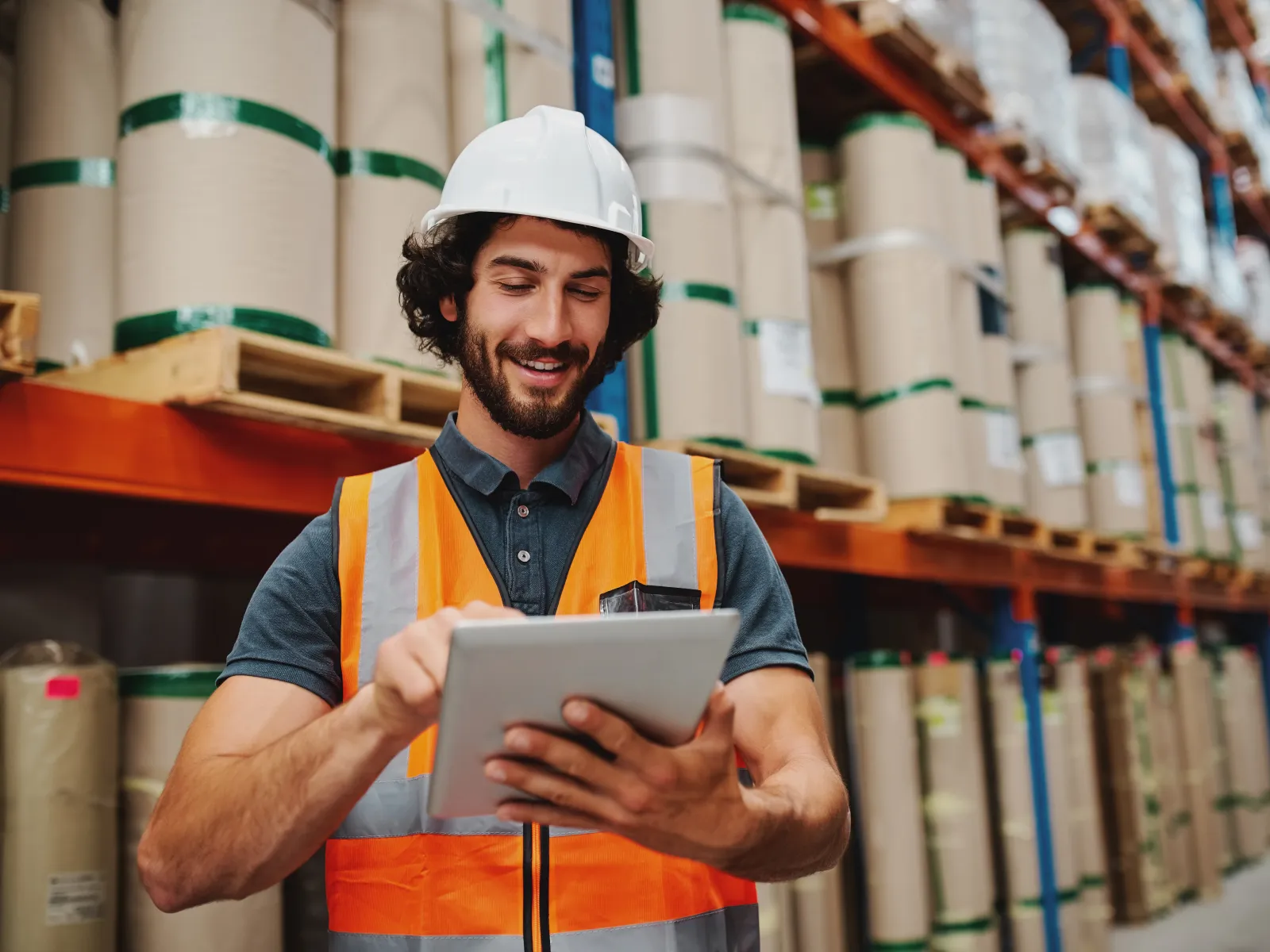 a man wearing a hard hat and safety vest holding a tablet
