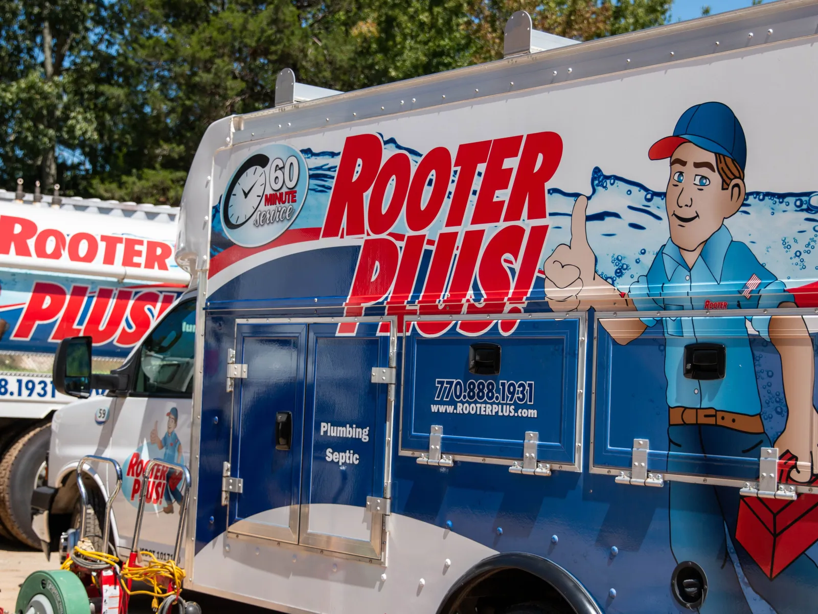 Brightly colored Rooter Plus! plumbing and septic service truck showcasing services in a residential area.