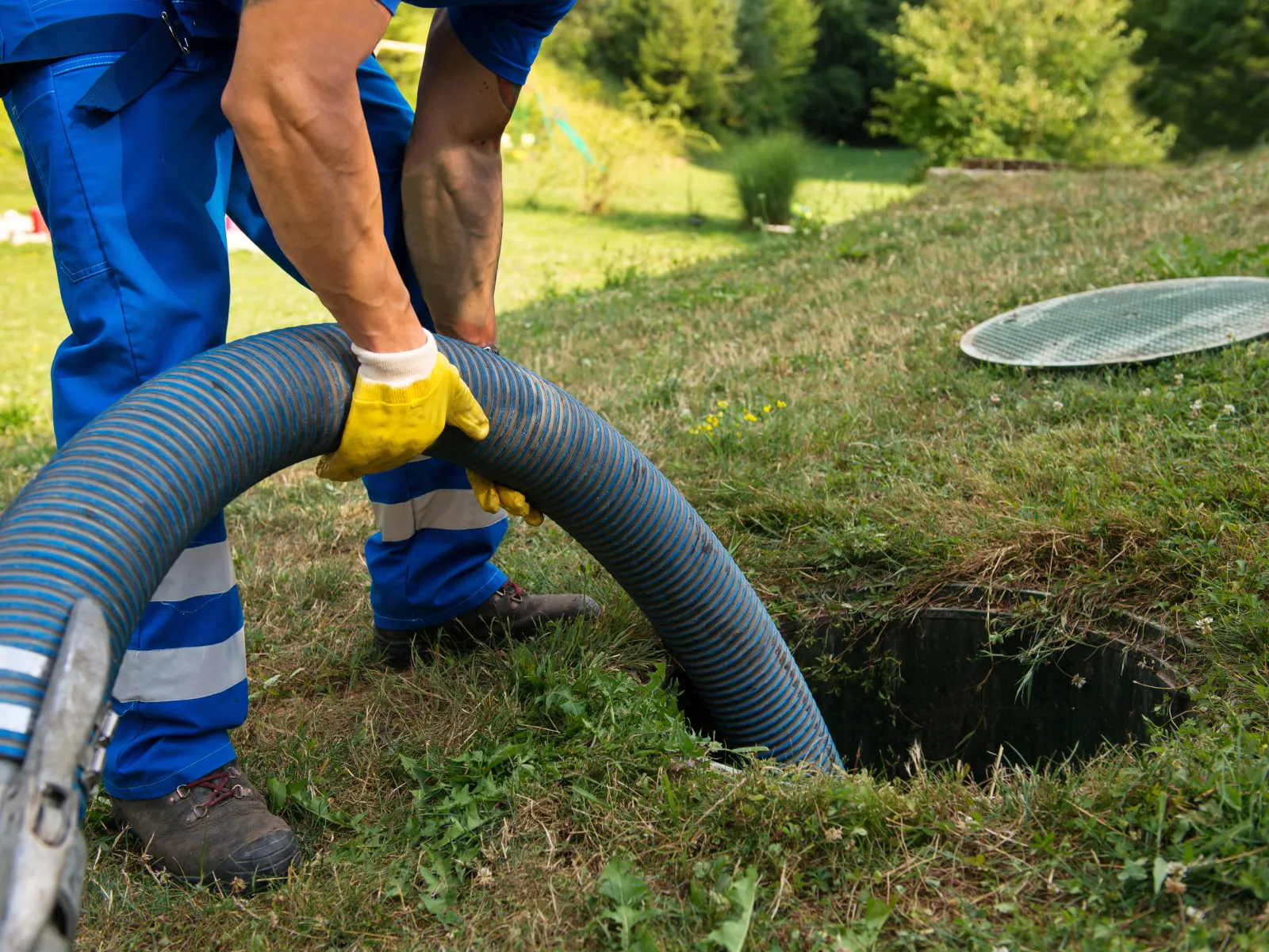 a person using a hose to water a hole in the ground