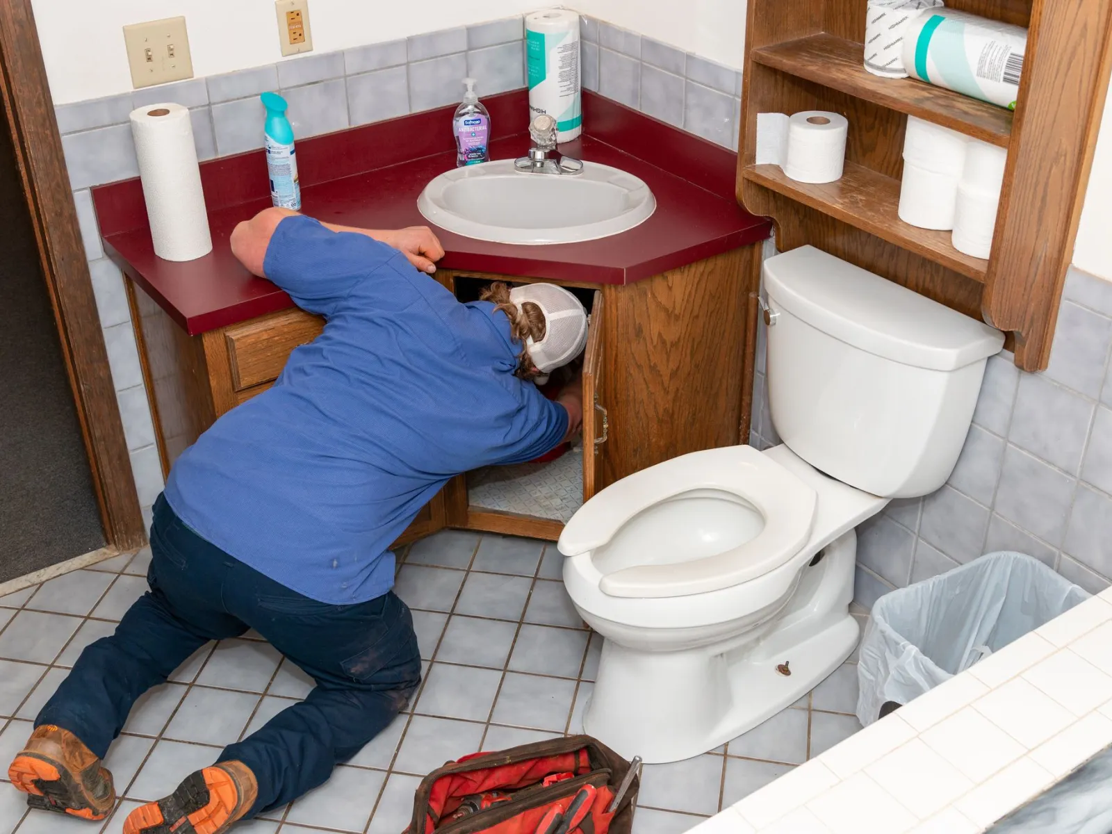 a plumber bending over to fix a toilet in atlanta