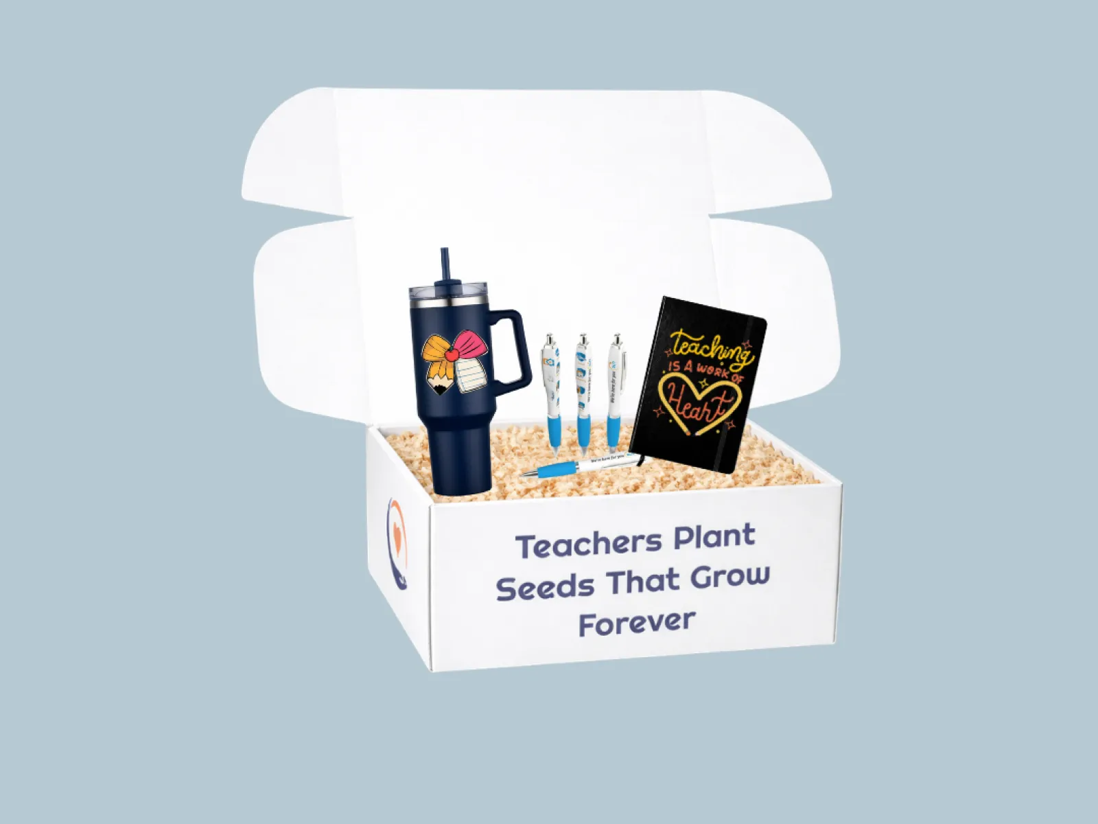 Teacher appreciation gift box with tumbler, pens, and notebook that reads Teaching is a work of heart.