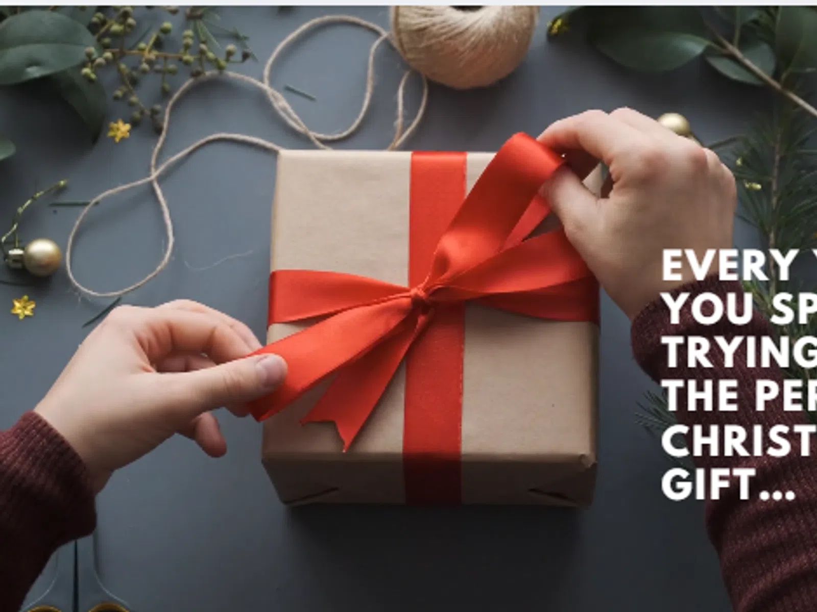 Hands tying a red ribbon on a brown gift box with Christmas decorations and message about finding the perfect gift.