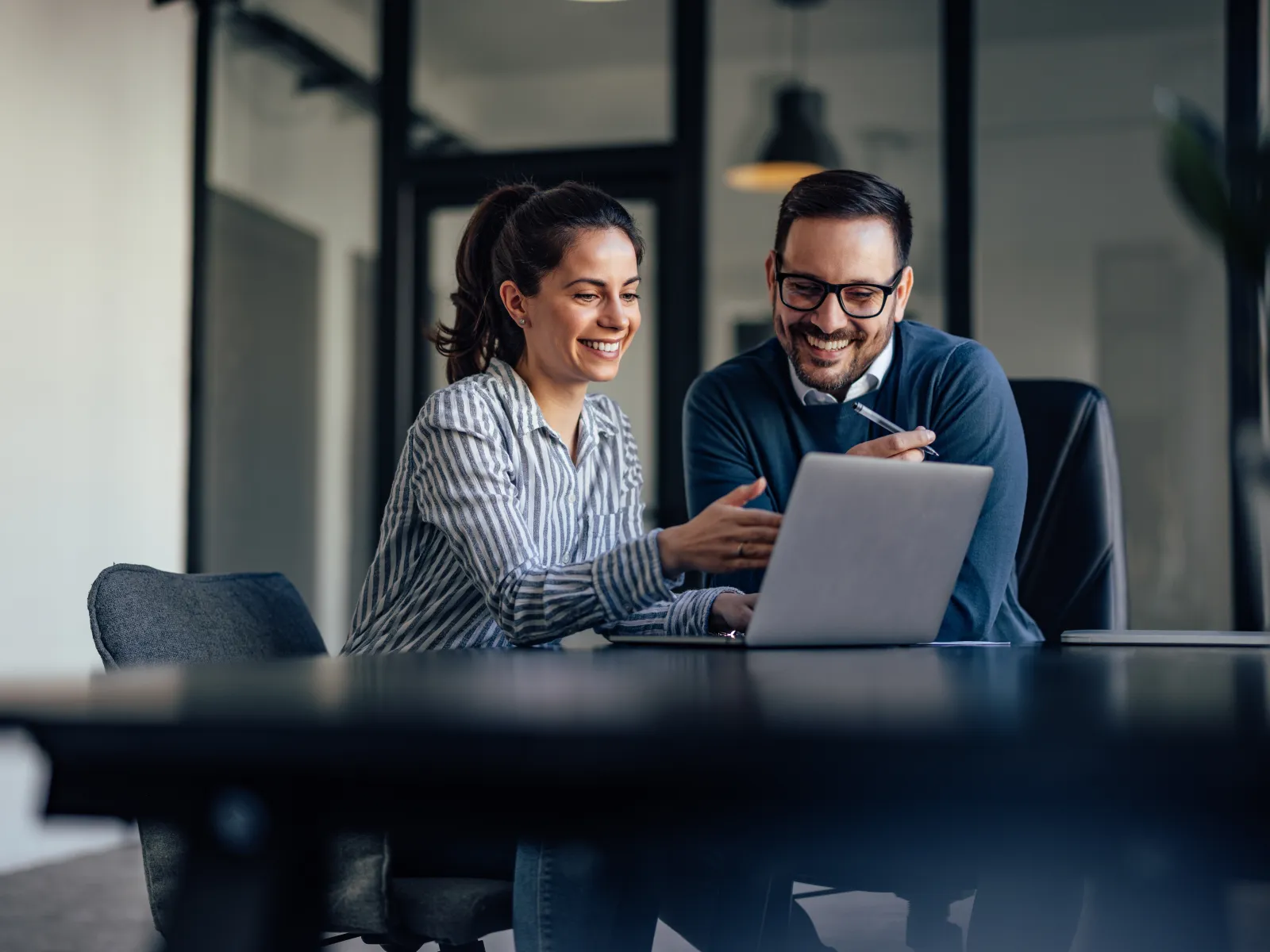 a man and a woman looking at a laptop