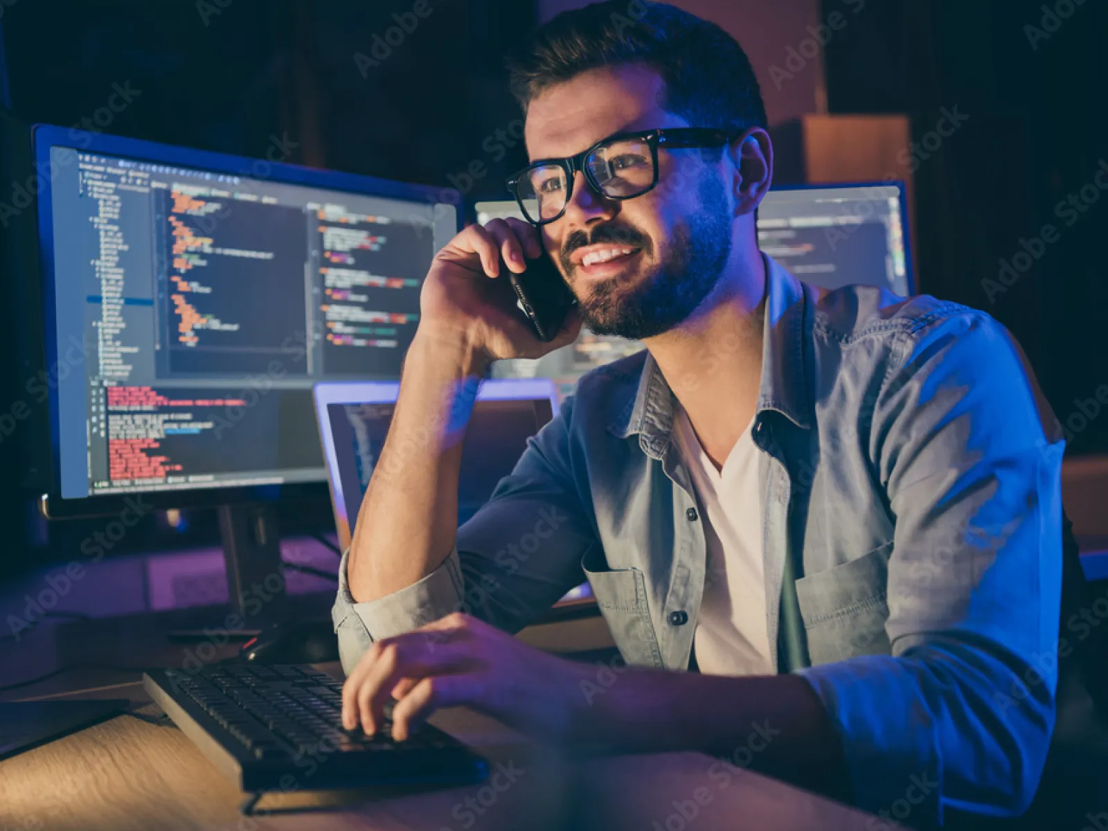 a man with a beard and glasses using a laptop