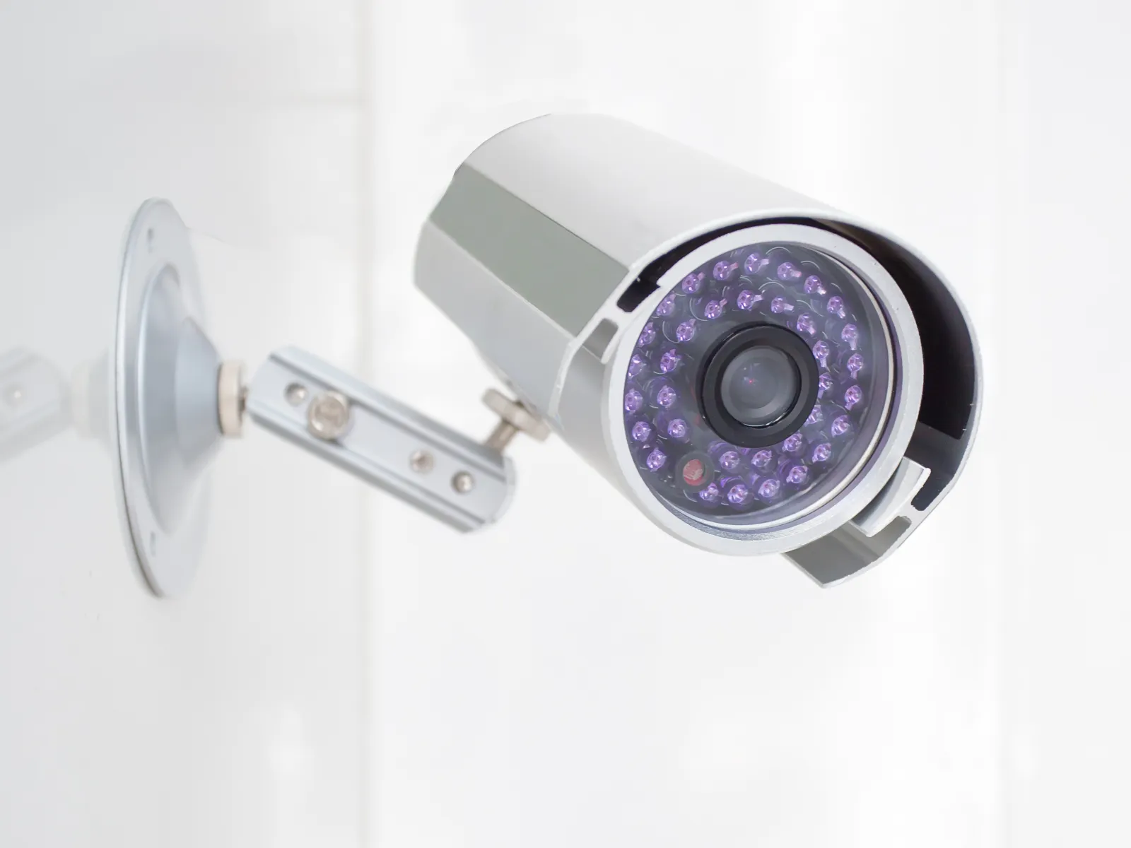 Close-up of a modern security camera mounted on a wall for surveillance.