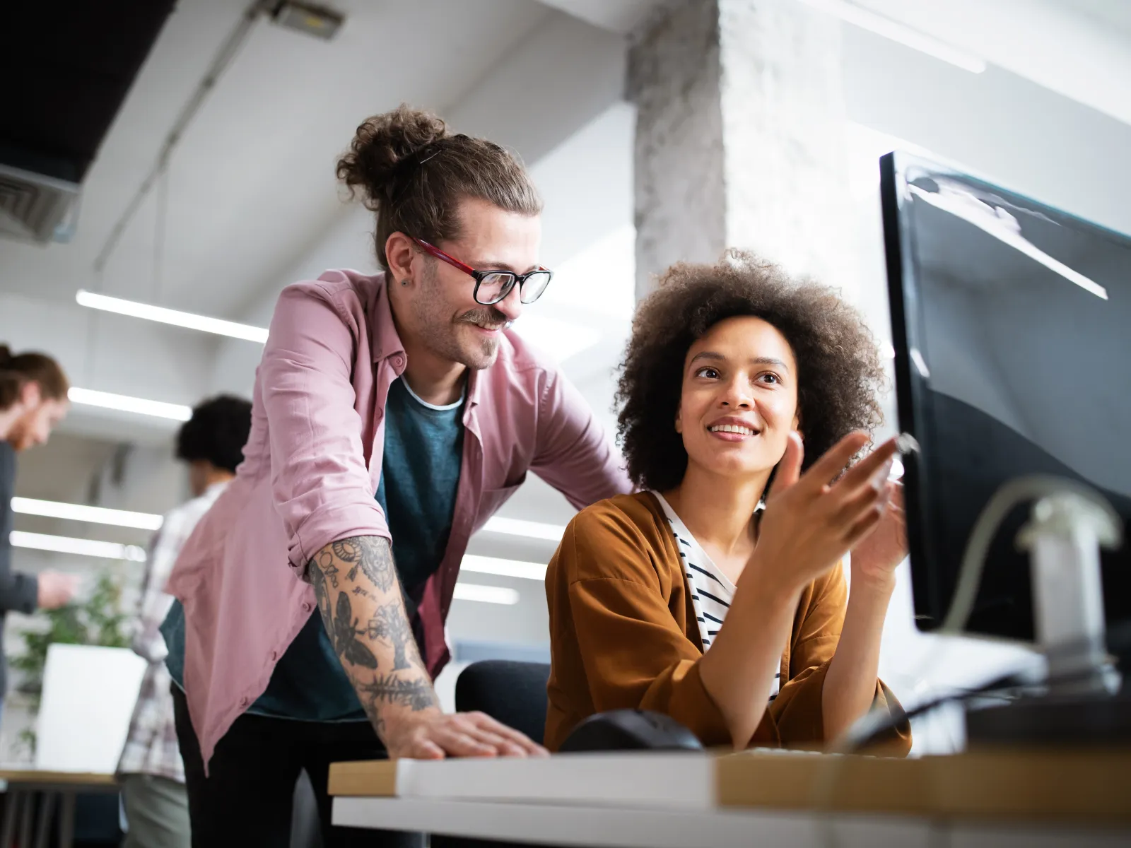 a man and a woman looking at a computer screen