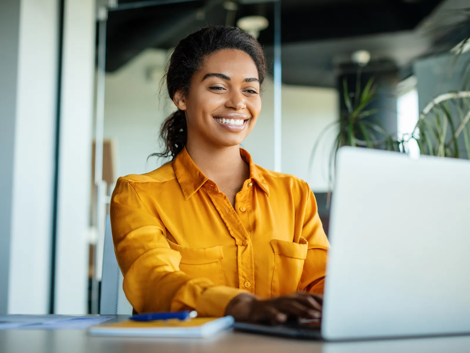 a person smiling at a laptop