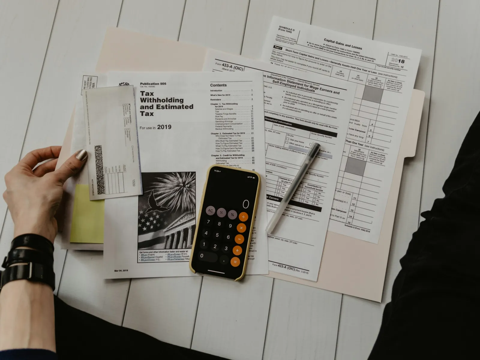 a person holding a phone and a newspaper