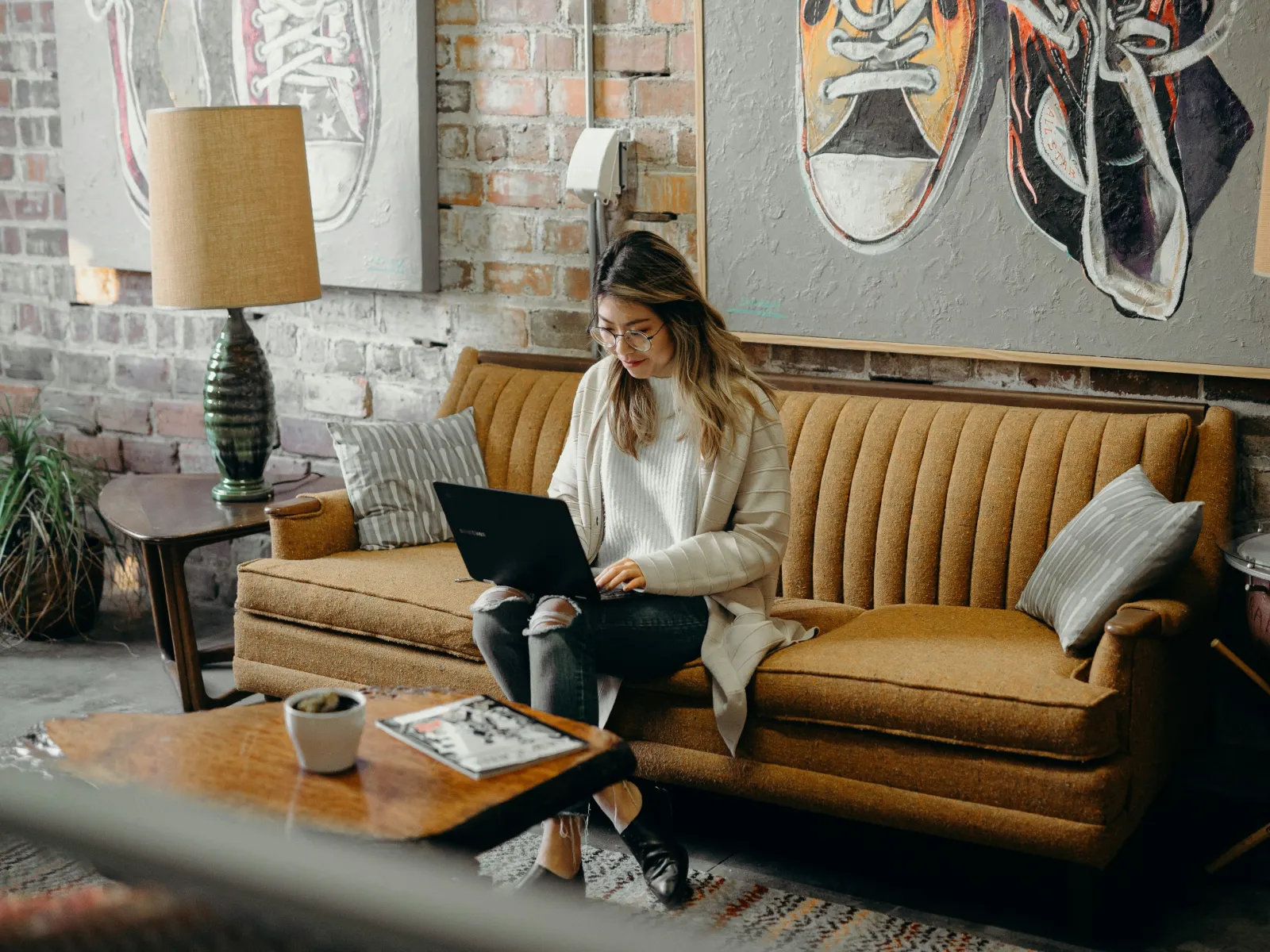 a woman sitting on a couch using a laptop