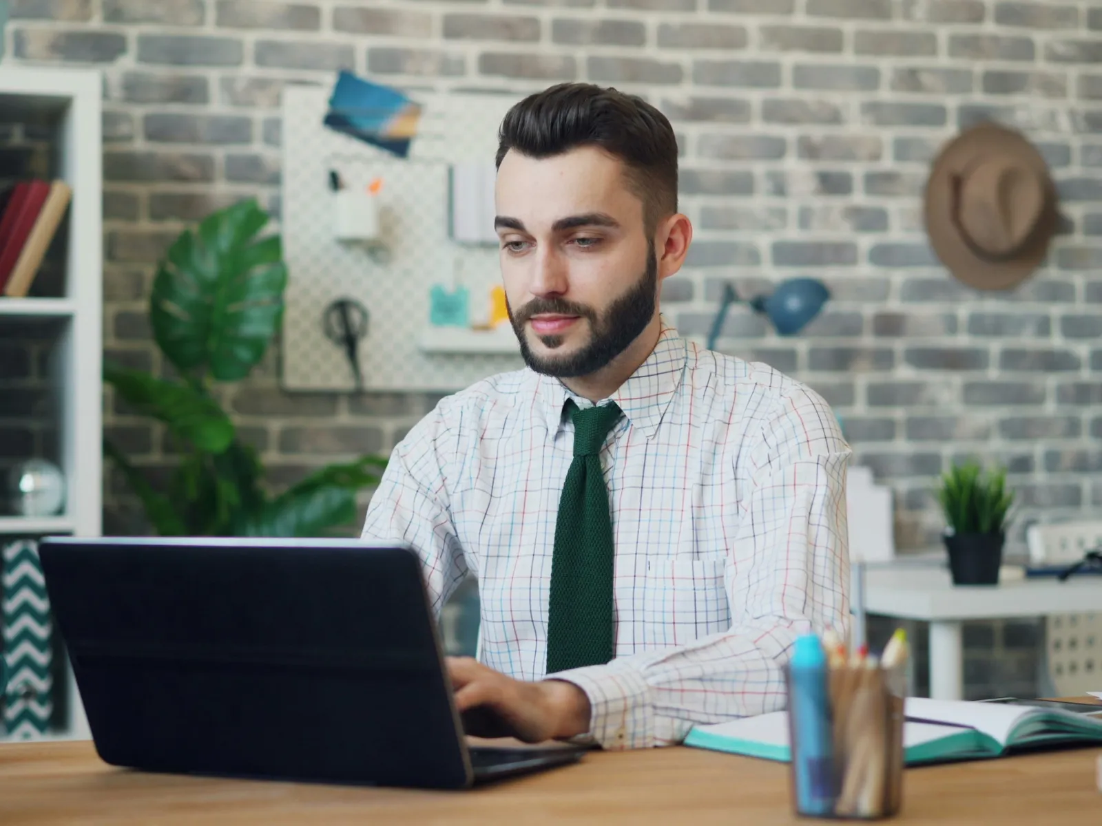 a man sitting at a desk with a laptop