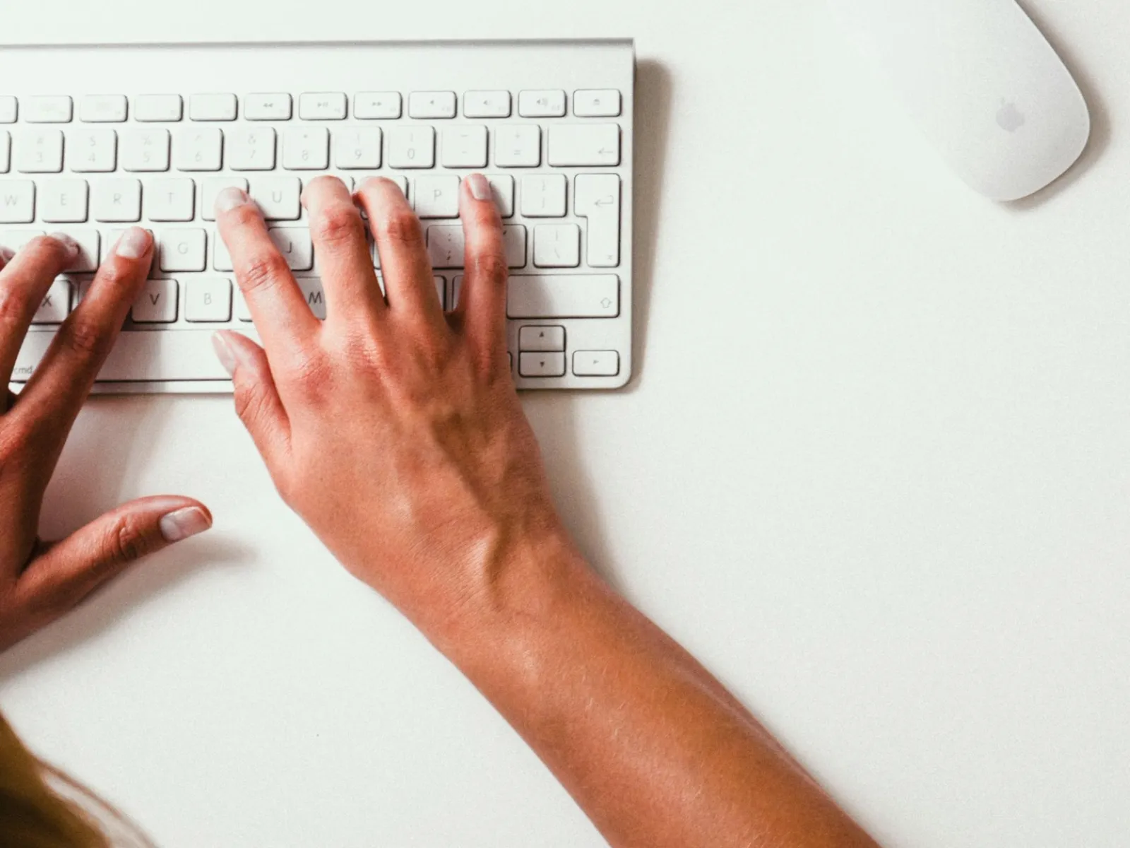 a person's hands on a white surface