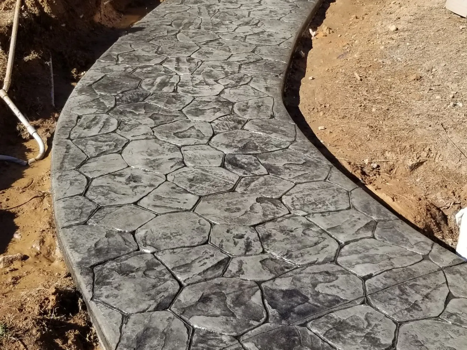 a stone walkway with a stone wall