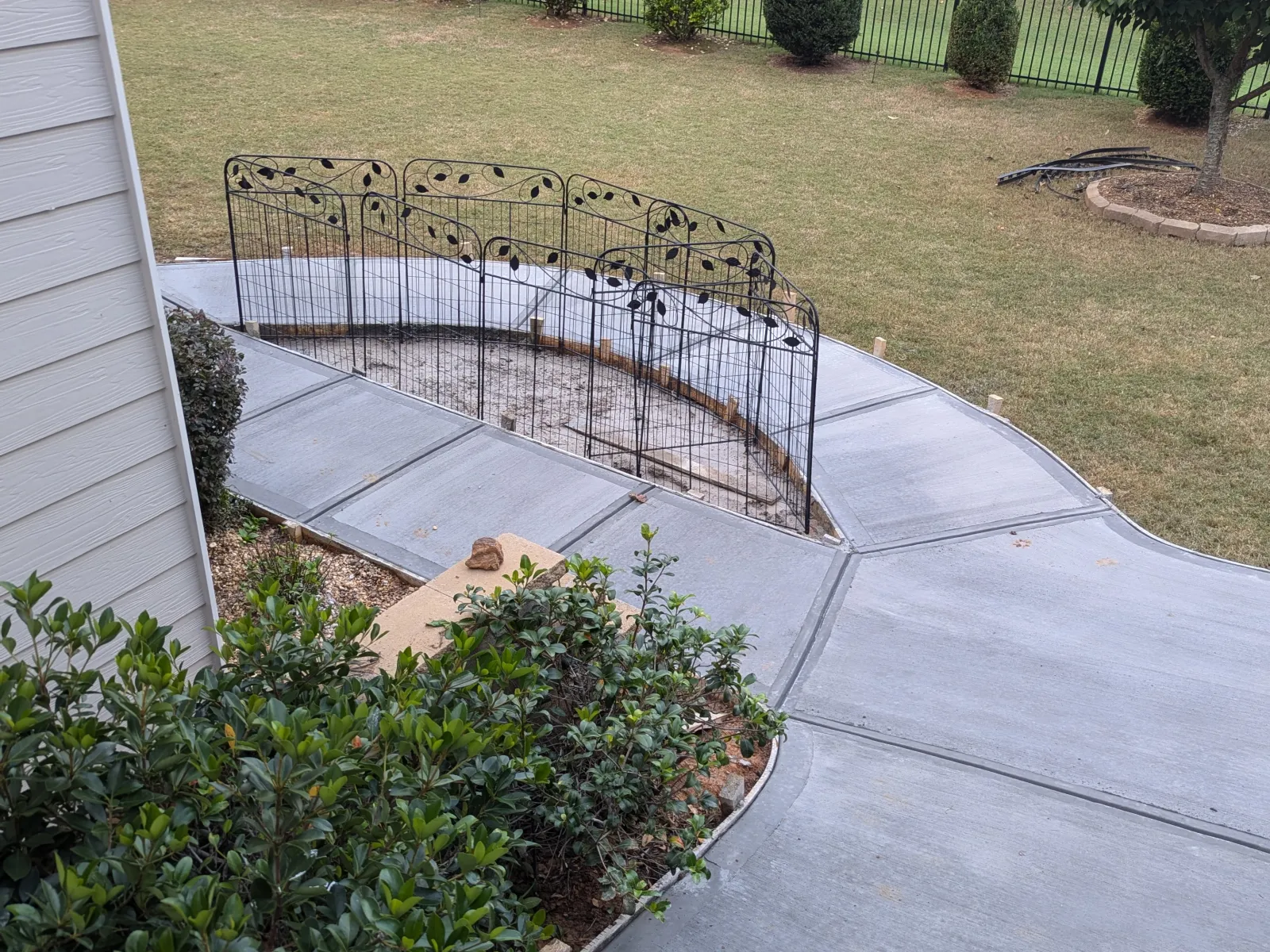 a backyard with a fence and a yard with a small garden