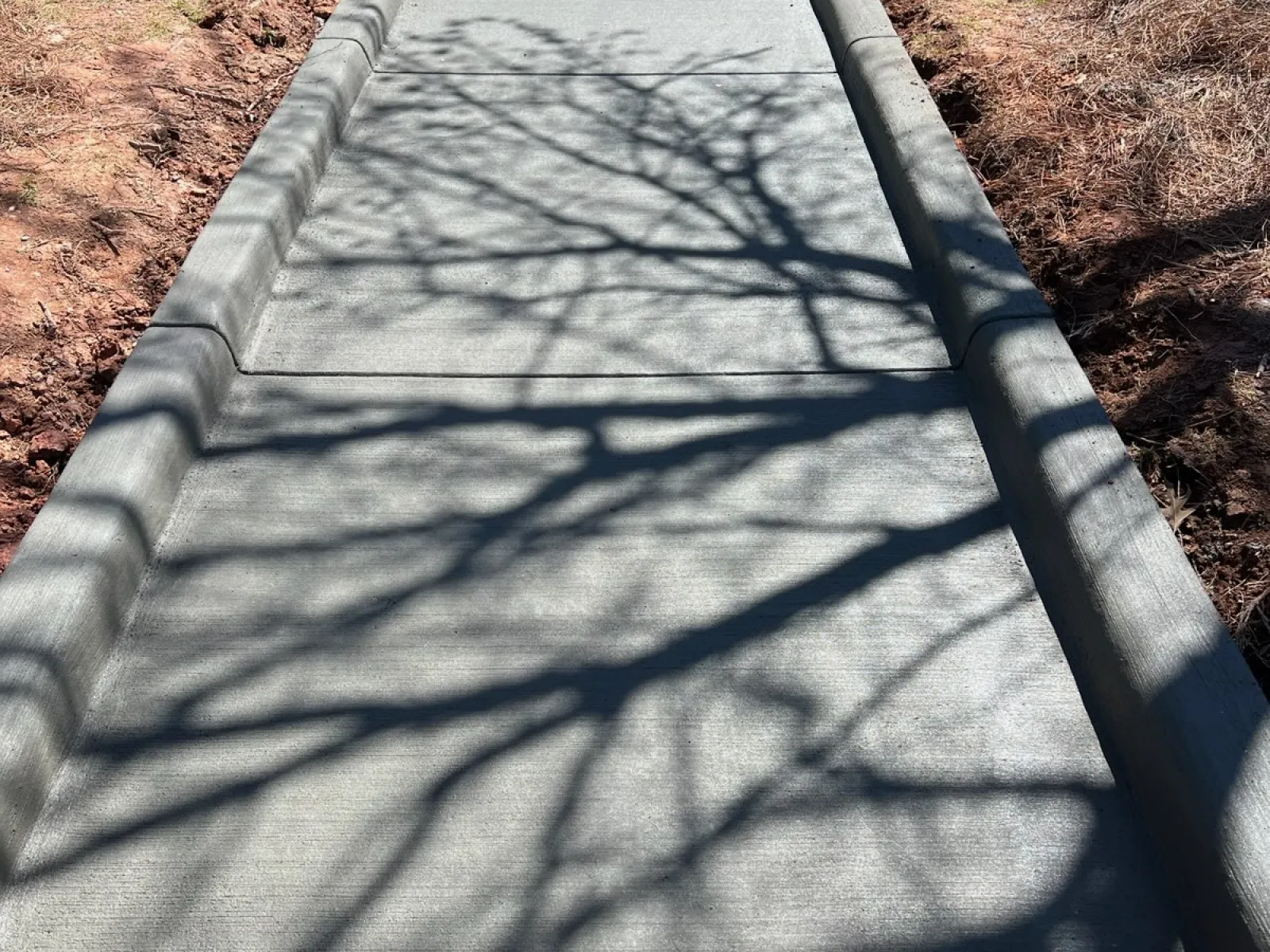 a sidewalk with a concrete walkway