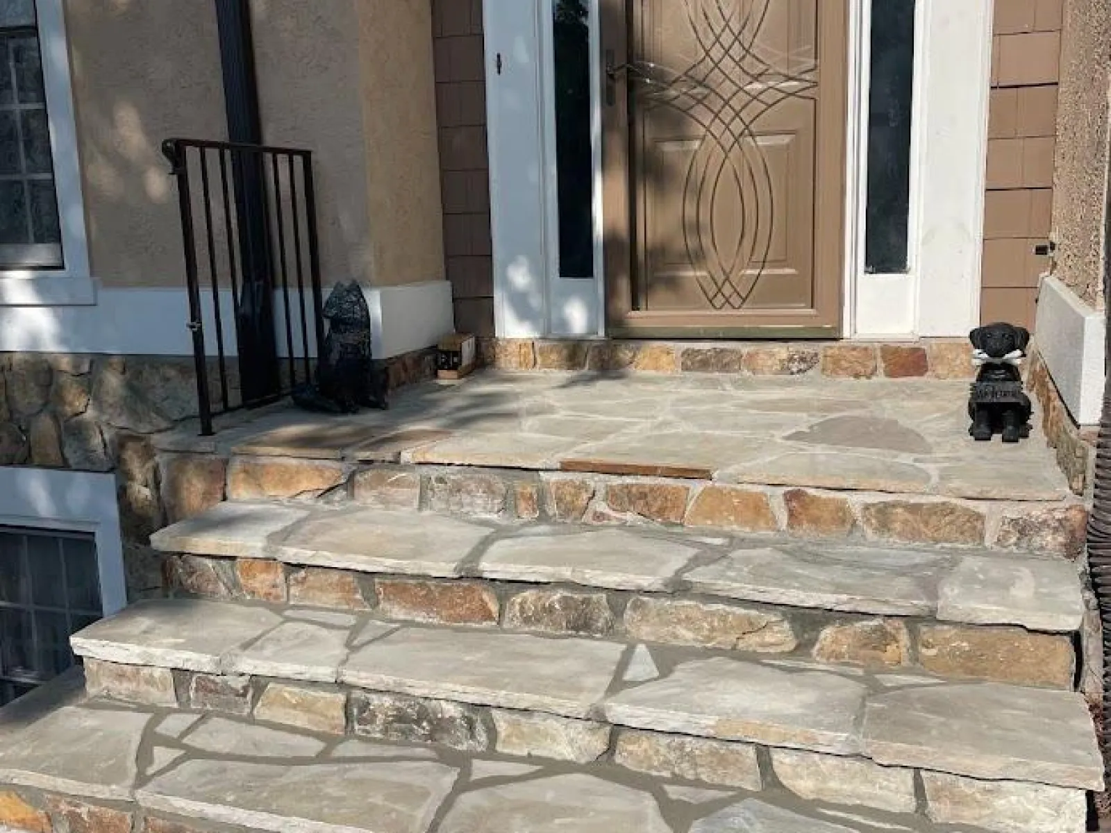 A stylish stone staircase leading up to an elegant front door with decorative sidelights.
