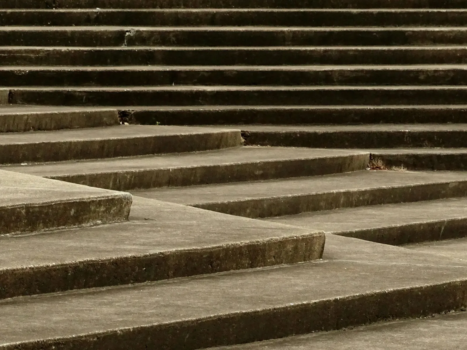 Close-up view of concrete steps with geometric lines and shadows creating a pattern of horizontal layers.
