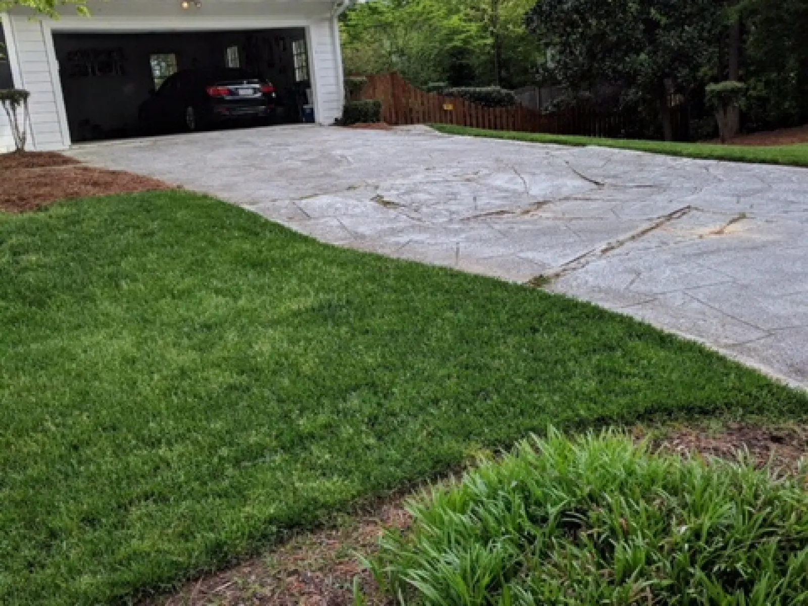 a driveway with a garage and grass