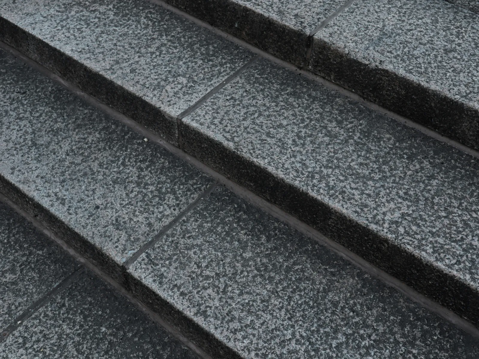 Close-up of textured gray stone steps with visible rough surface and clean lines