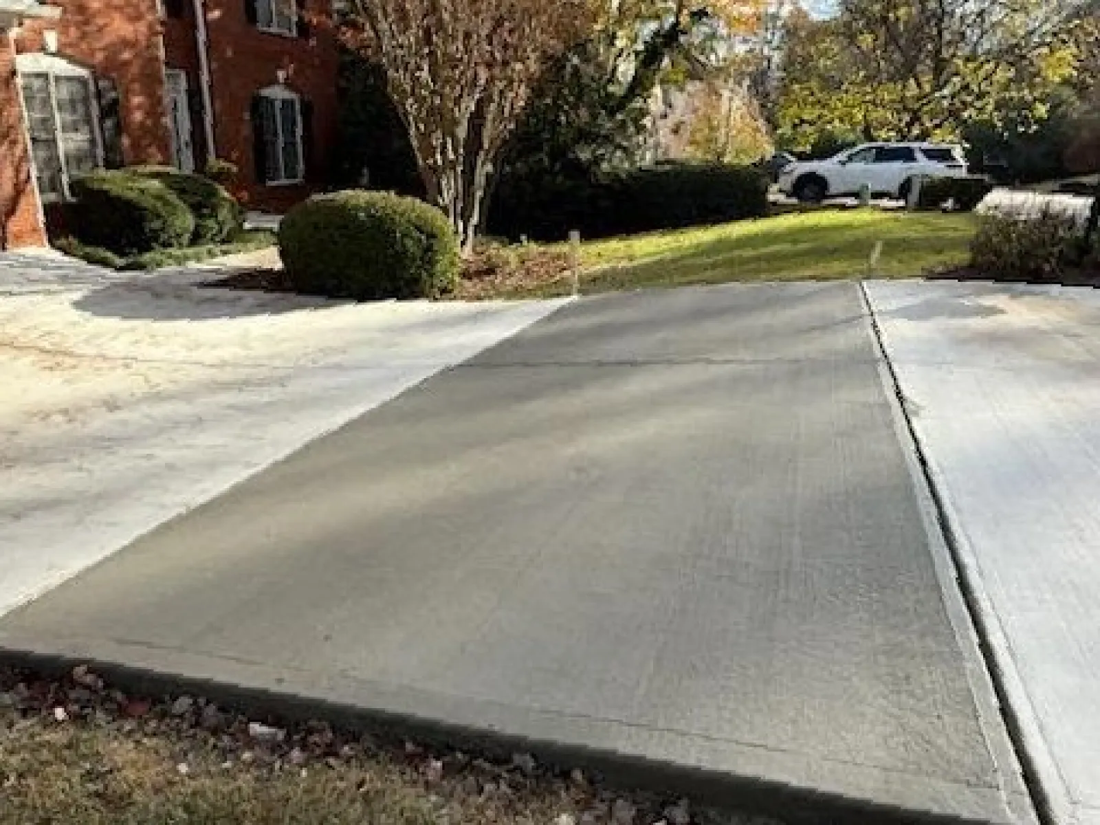 a driveway with a car parked in the background
