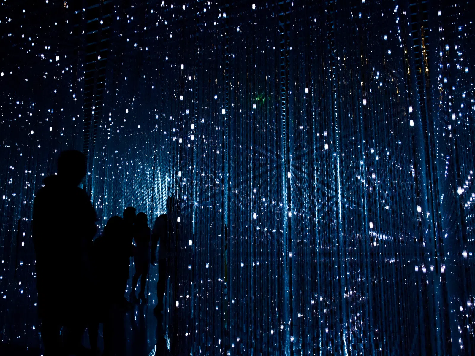 a group of people looking at a wall of lights