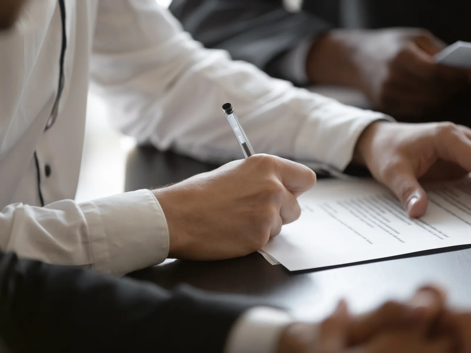 a person signing a piece of paper