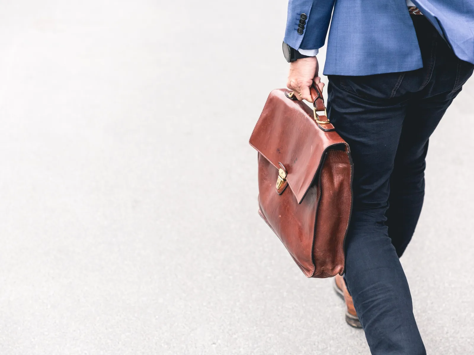 a man carrying a brown briefcase