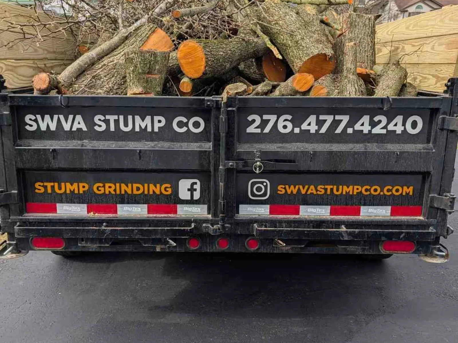 Back of truck loaded with cut tree logs and branches, advertising SWVA Stump Co and stump grinding services.