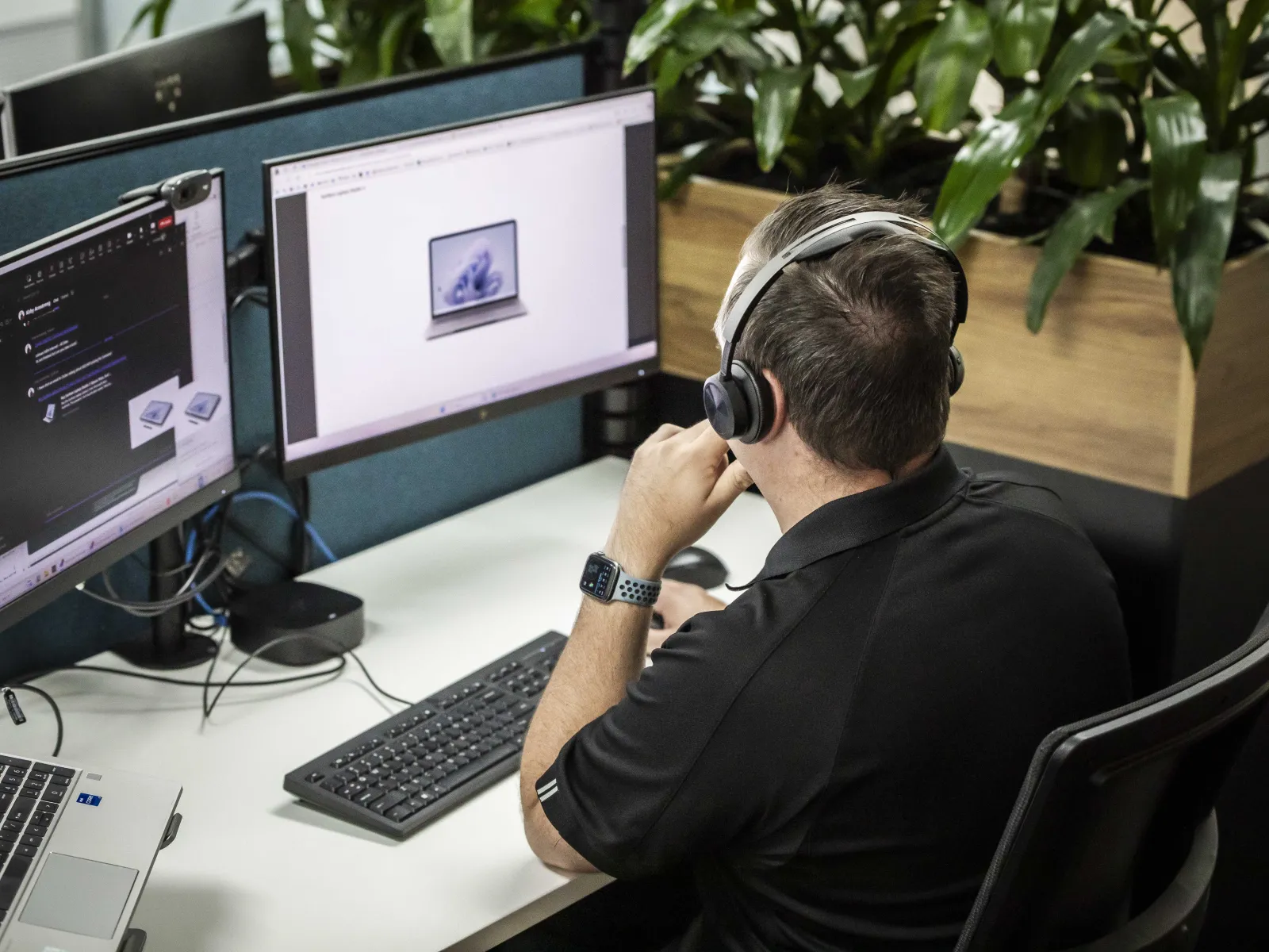 a man sitting at a desk with multiple computers