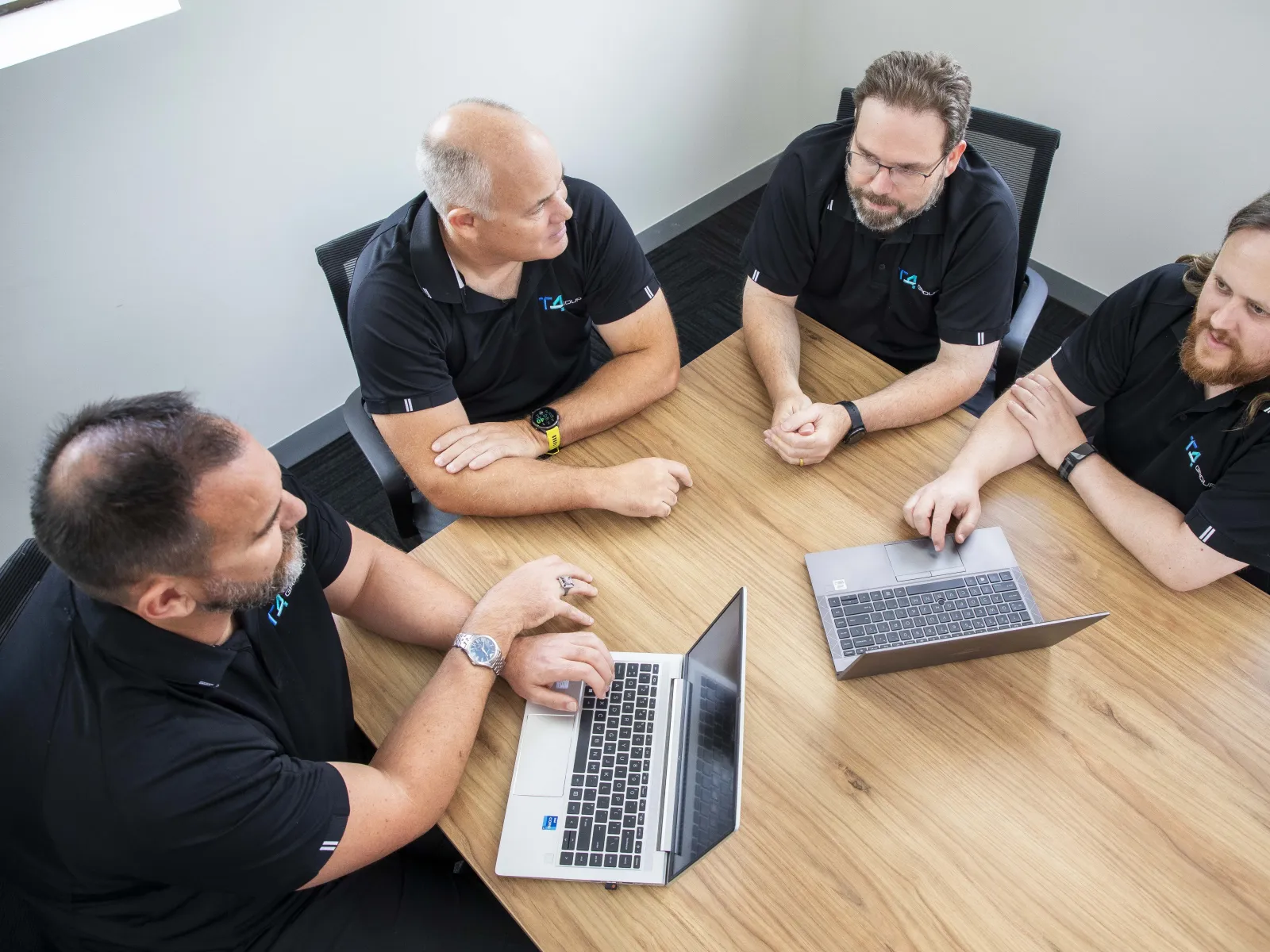 a group of people sitting around a table looking at a laptop