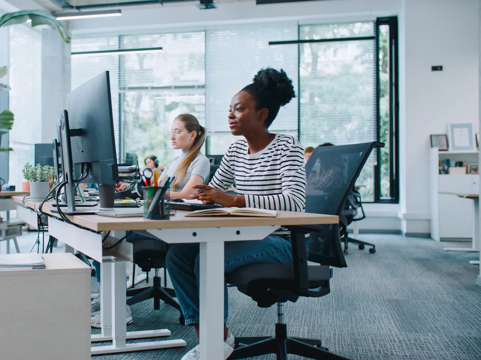a group of people sitting at a table with computers
