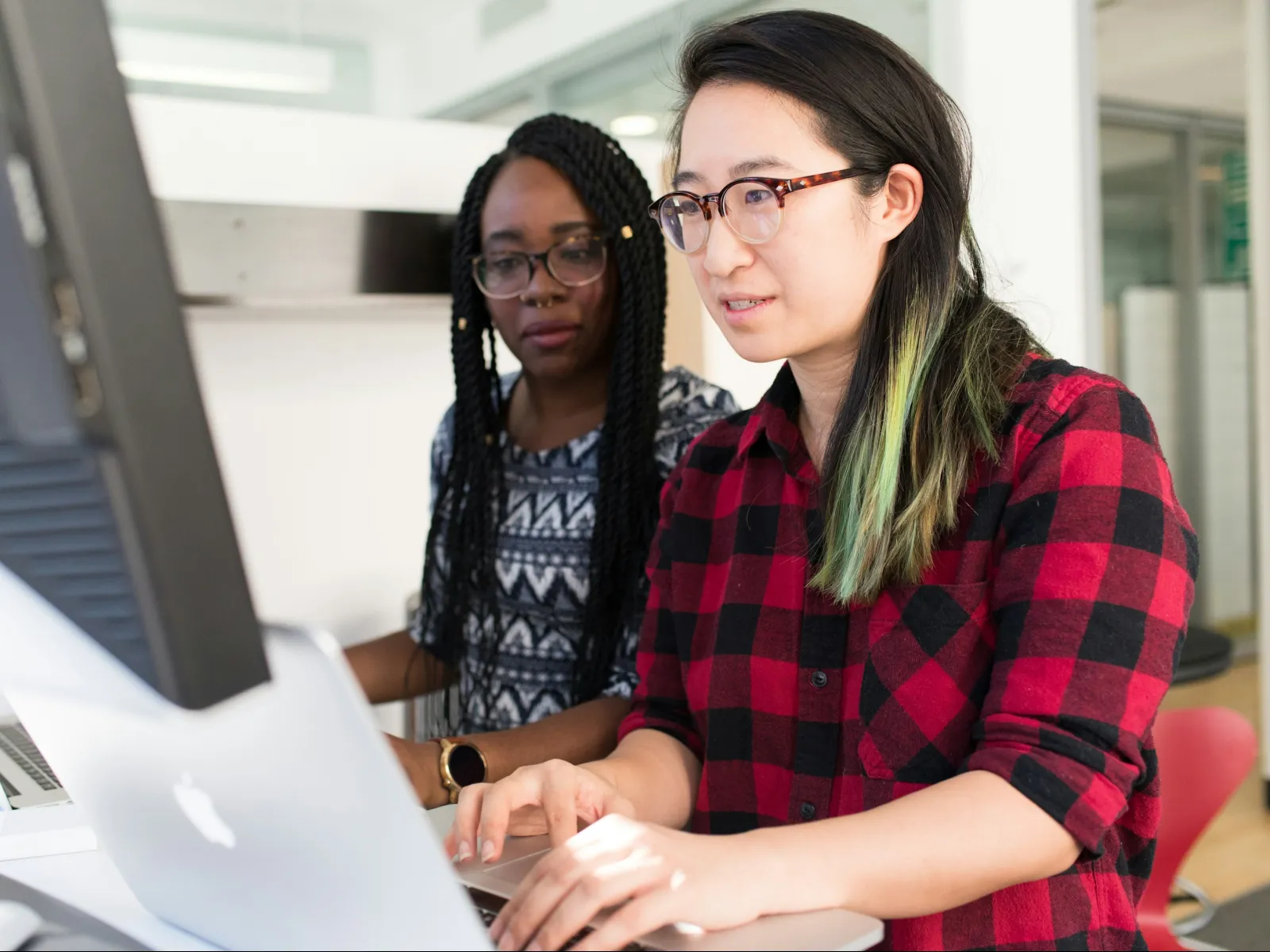a couple of women looking at a laptop
