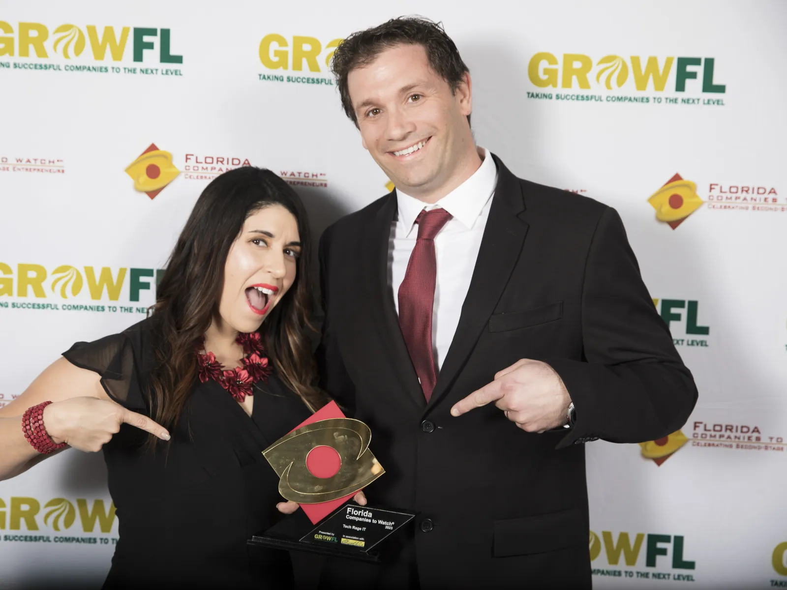 a man and woman holding a trophy