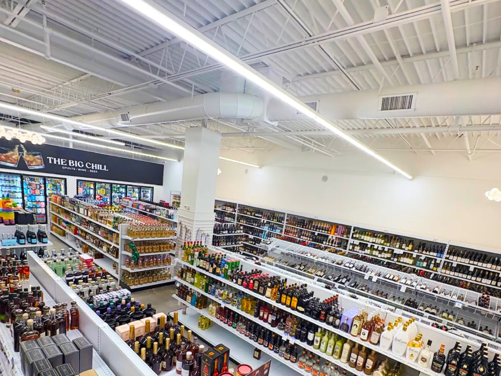 Interior view of a liquor store with well-organized shelves stocked with various alcoholic beverages and spirits.