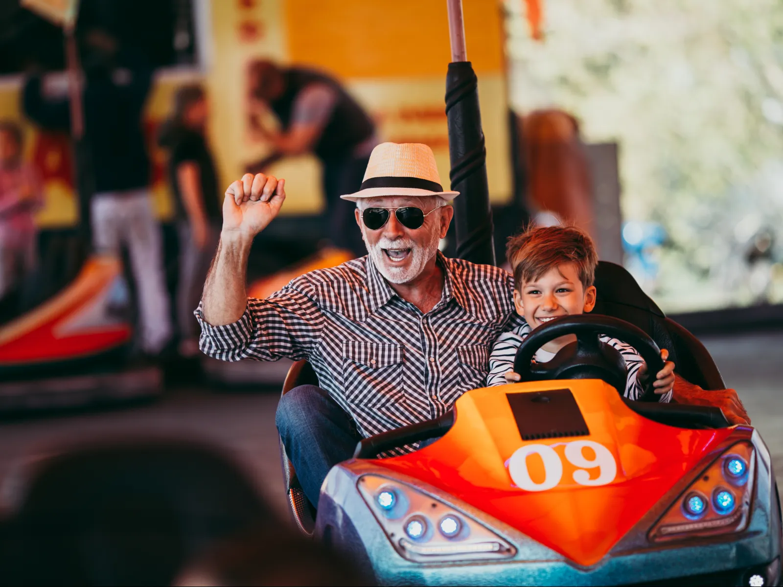 a man and a boy riding a toy car