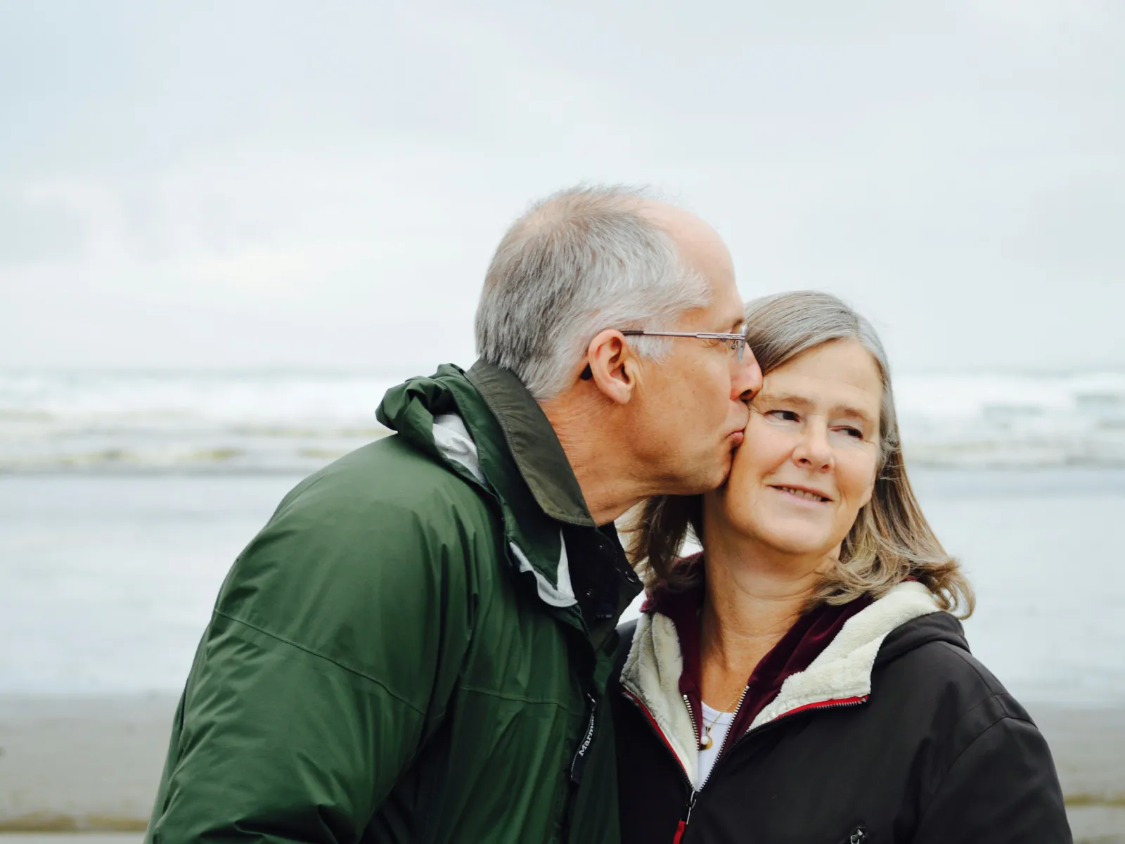 a man kissing a woman on the cheek