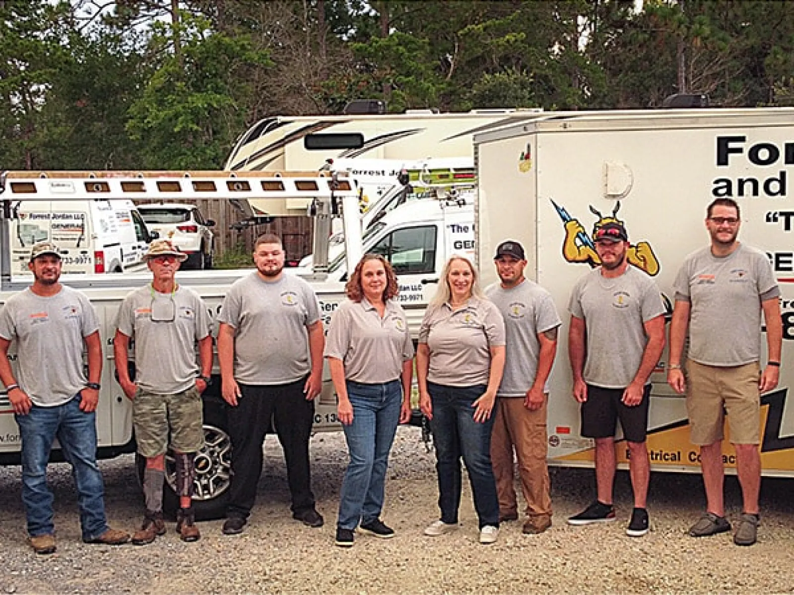 Team of professionals from Forrestel and Associates posing in front of their service vehicles.