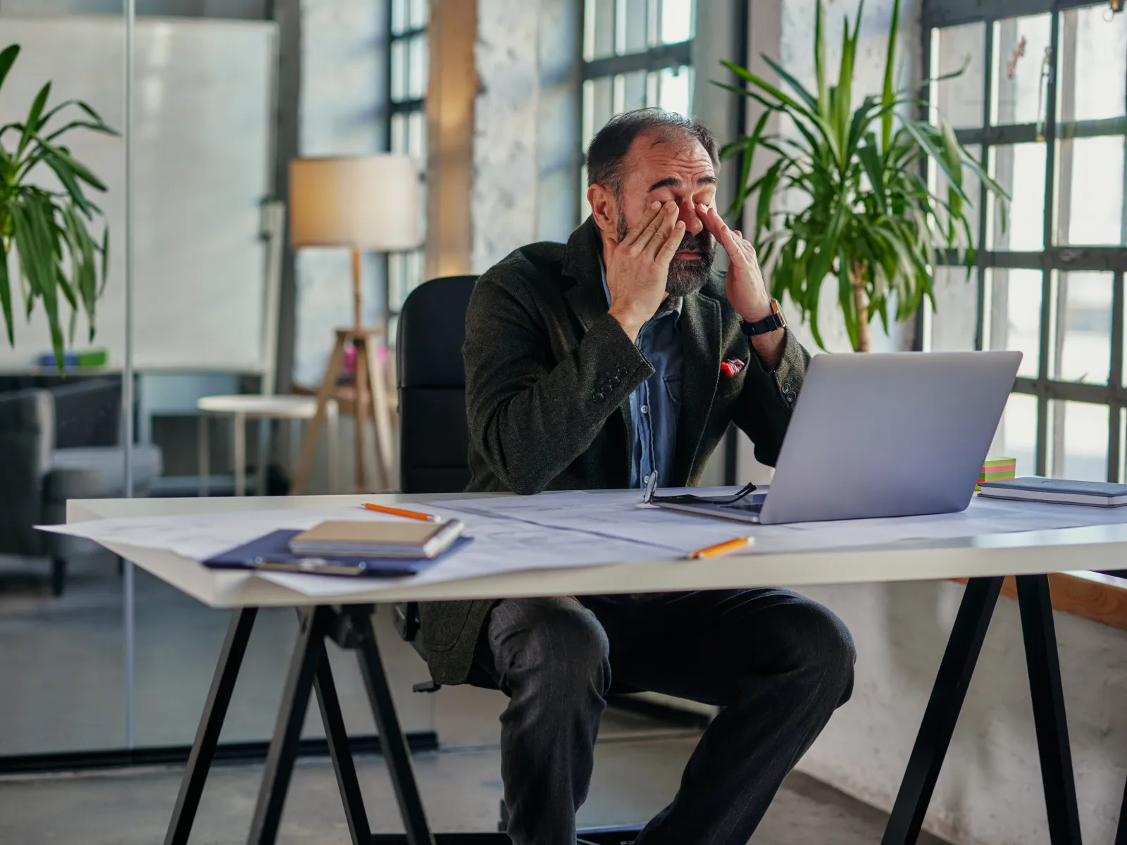 a person sitting at a table with a laptop and a phone