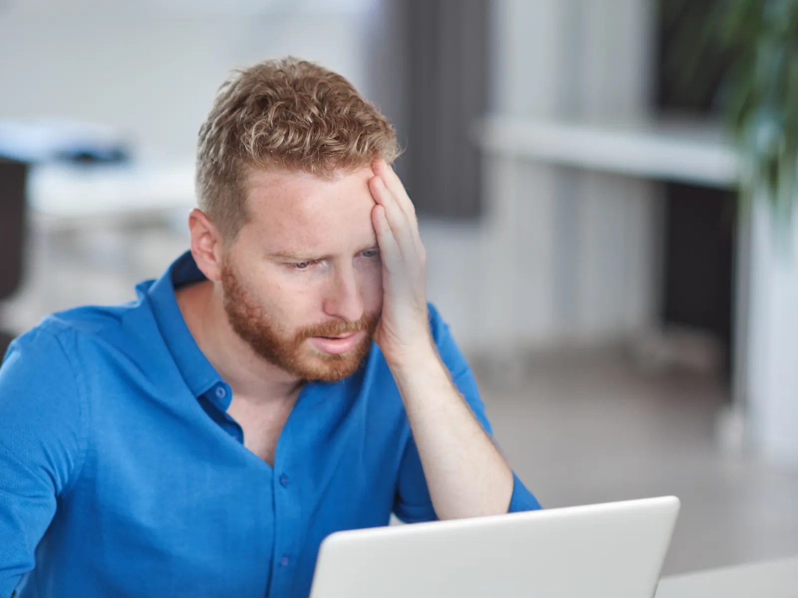 a person sitting at a table with the head on the hand