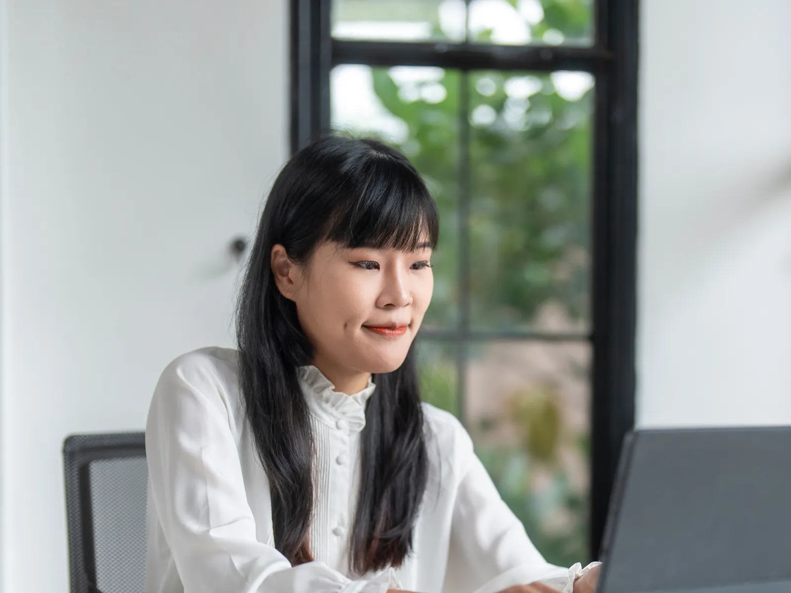 a woman sitting at a table with a laptop