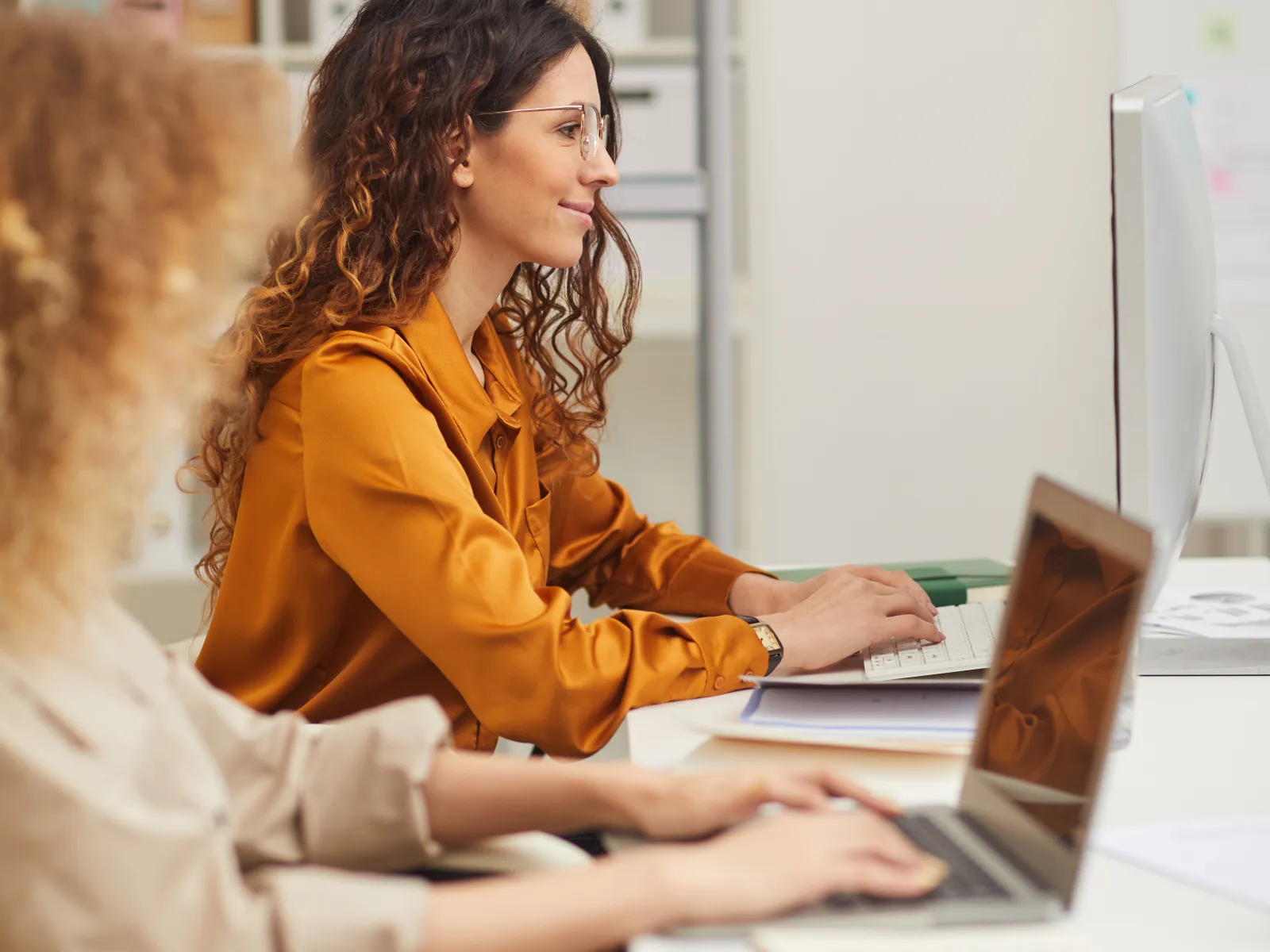 a woman showing something on the laptop to another woman
