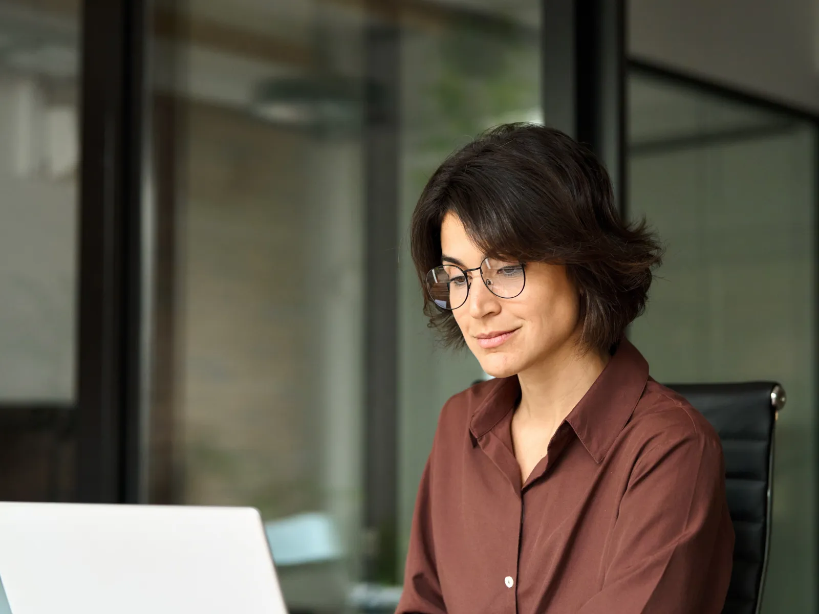 a woman sitting at a desk with a laptop