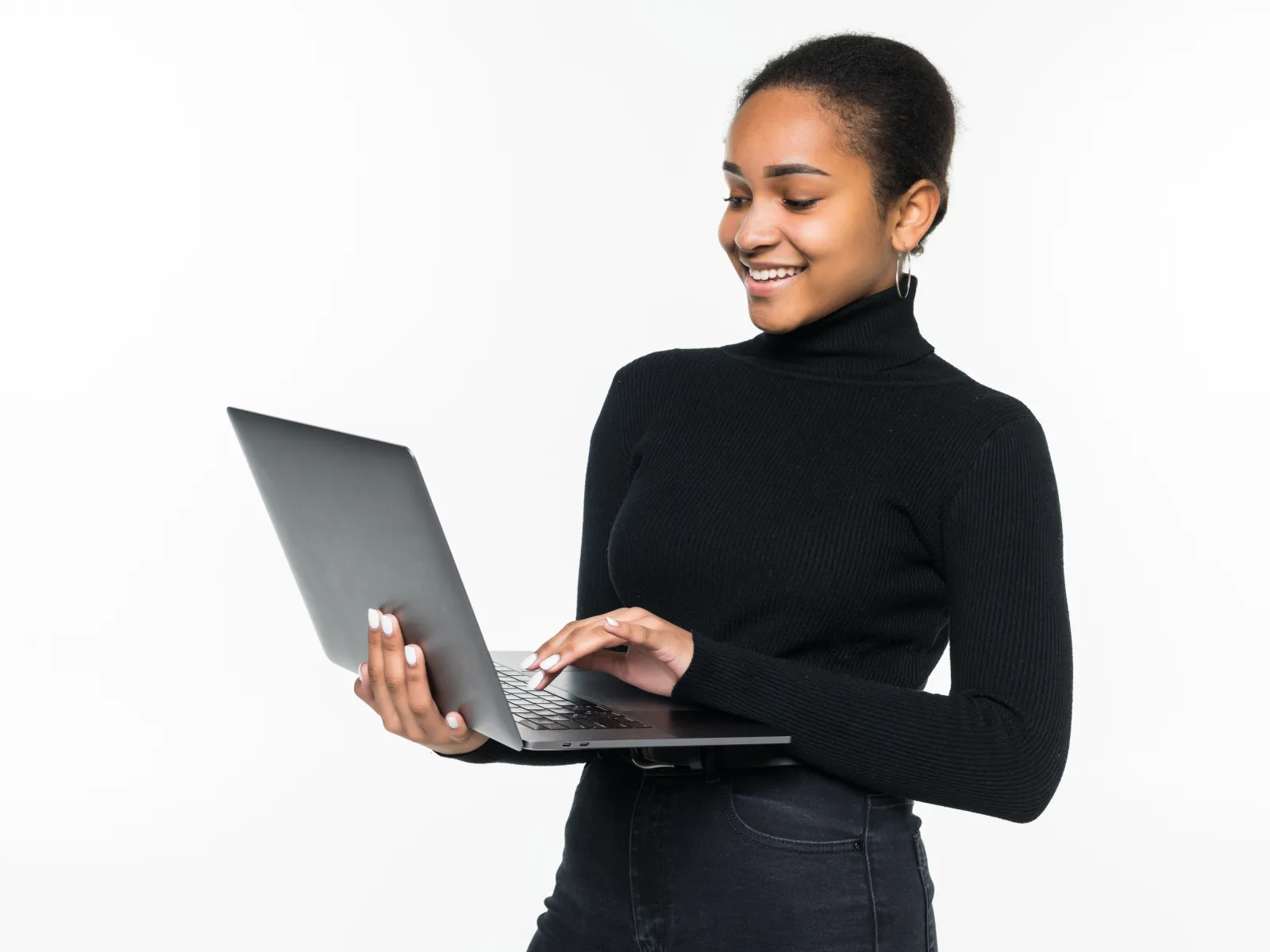 Young woman in black turtleneck using laptop and smiling against white background