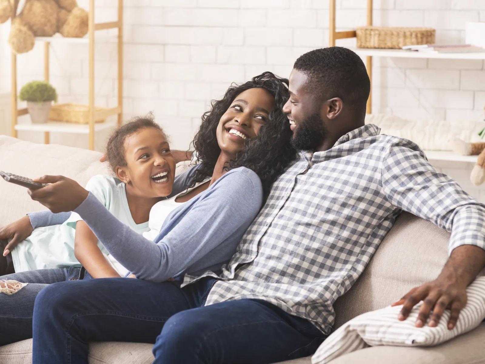 A family sitting on a couch, happy because the Plumbing Paramedics helped them with emergency plumbing service