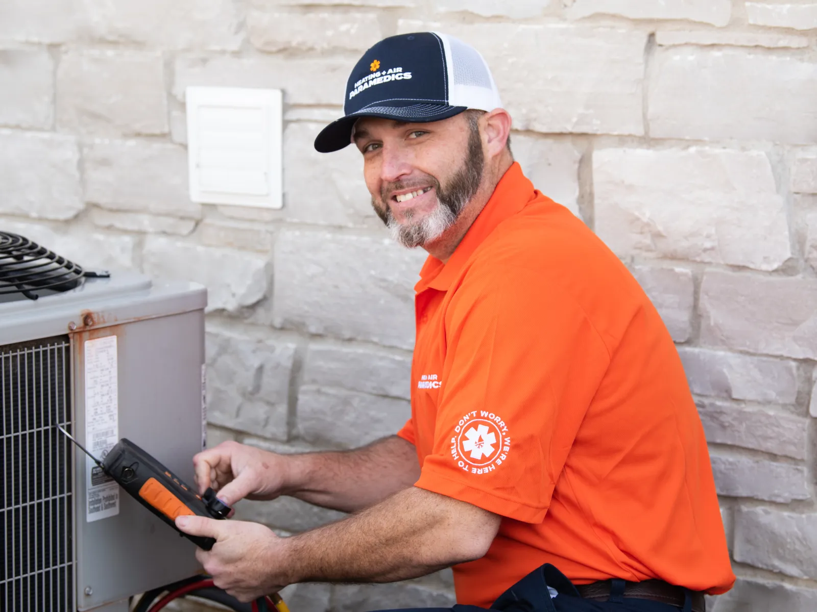 Heating + Air Paramedics Raleigh HVAC technician working on a unit outside a home in North Carolina