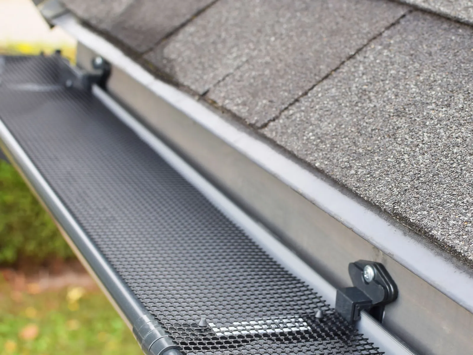 Close-up of a mesh gutter guard installed on a house roof to prevent debris buildup in gutters.