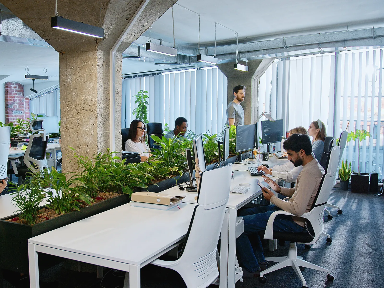 a group of people sitting at desks in an office